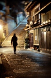 13933871-woman-walking-alone-along-a-cobblestone-road-at-night-in-kyoto-japan