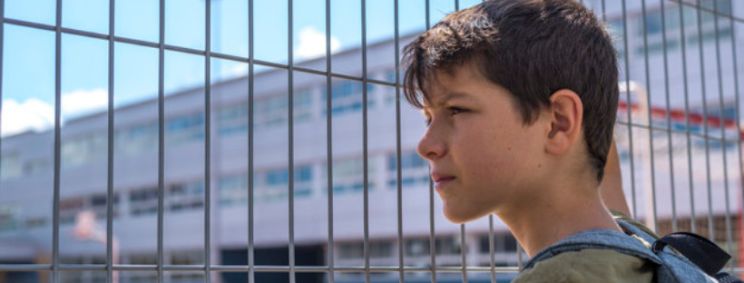 Kid in front of a school gate